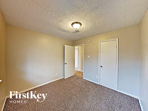 a bedroom with a carpeted floor and a door to a closet