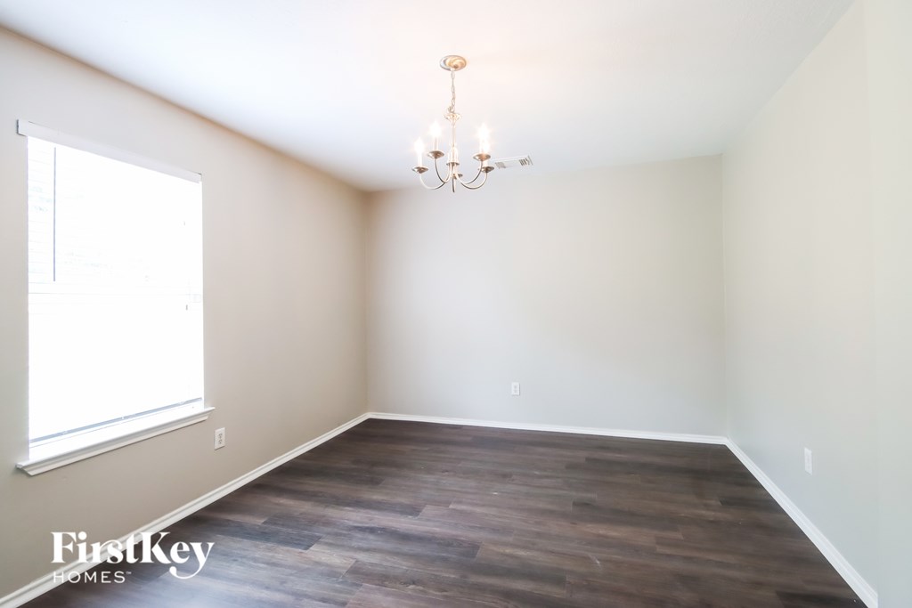 A room with a wooden floor and a chandelier.