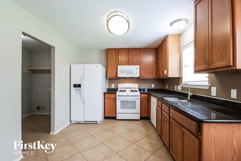 A kitchen with wooden cabinets and a white fridge.