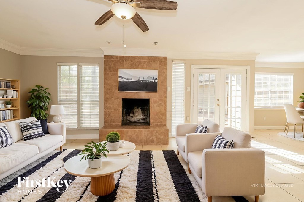 A living room with a fireplace and a painting above it.