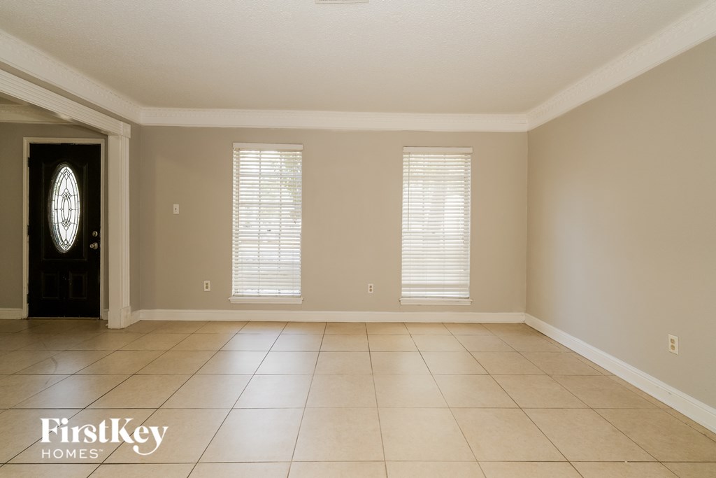 A spacious room with a door and two windows.
