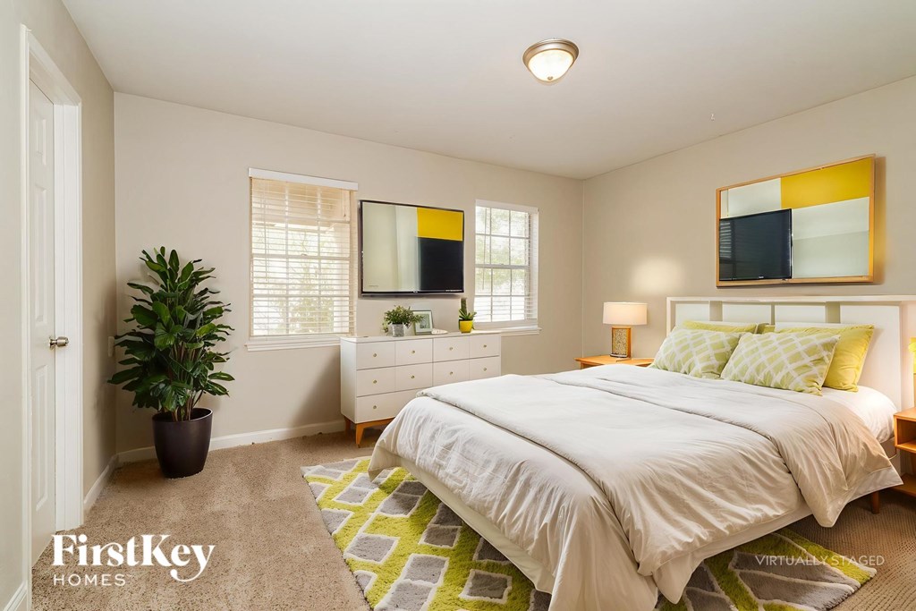 A bedroom with a bed, dresser, and mirror.
