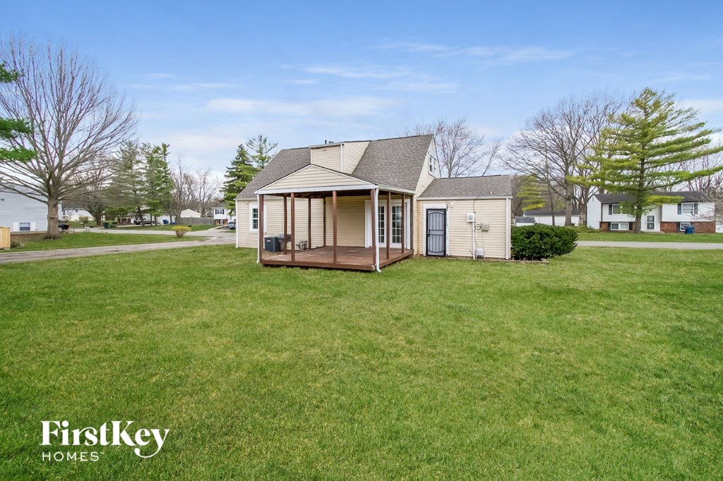 a small house with a porch in a grassy yard