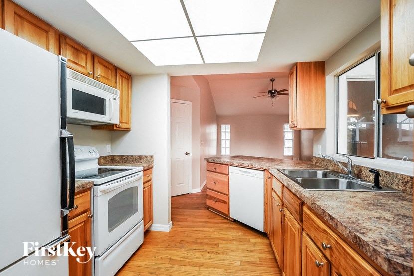 a kitchen with wooden cabinets and white appliances