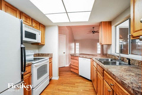 a kitchen with wooden cabinets and white appliances