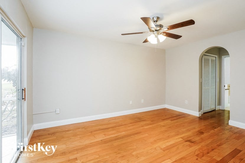 a living room with a wood floor and a ceiling fan
