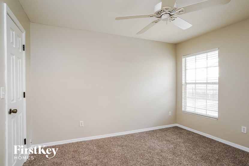 a bedroom with a ceiling fan and a window