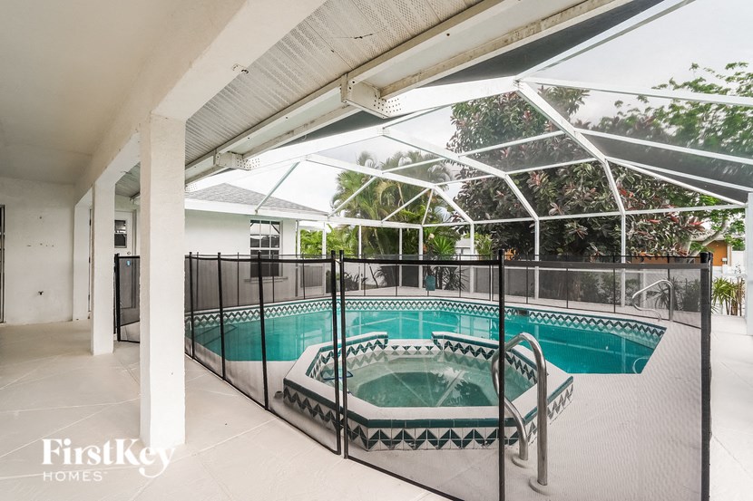 an indoor pool with a hot tub and a pool fence