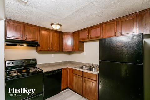 A kitchen with wooden cabinets and black appliances.