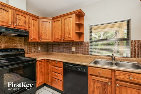 A kitchen with wooden cabinets and a black stove top oven.