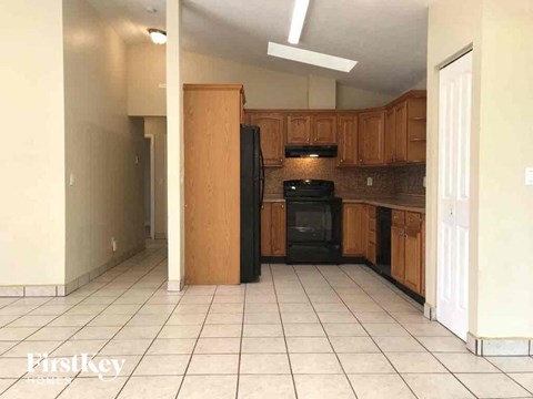 A kitchen with a black oven and wooden cabinets.