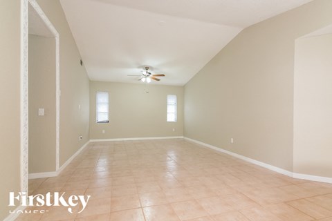 a empty living room with a ceiling fan