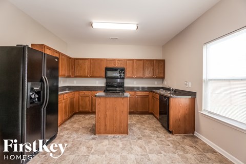 a kitchen with wooden cabinets and a black refrigerator
