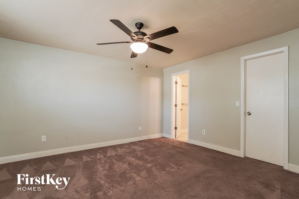 the living room of an empty house with a ceiling fan