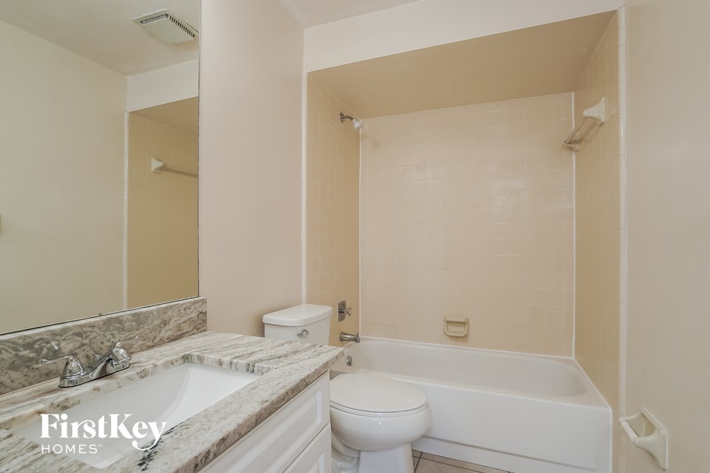 a bathroom with a toilet and a tub and a sink