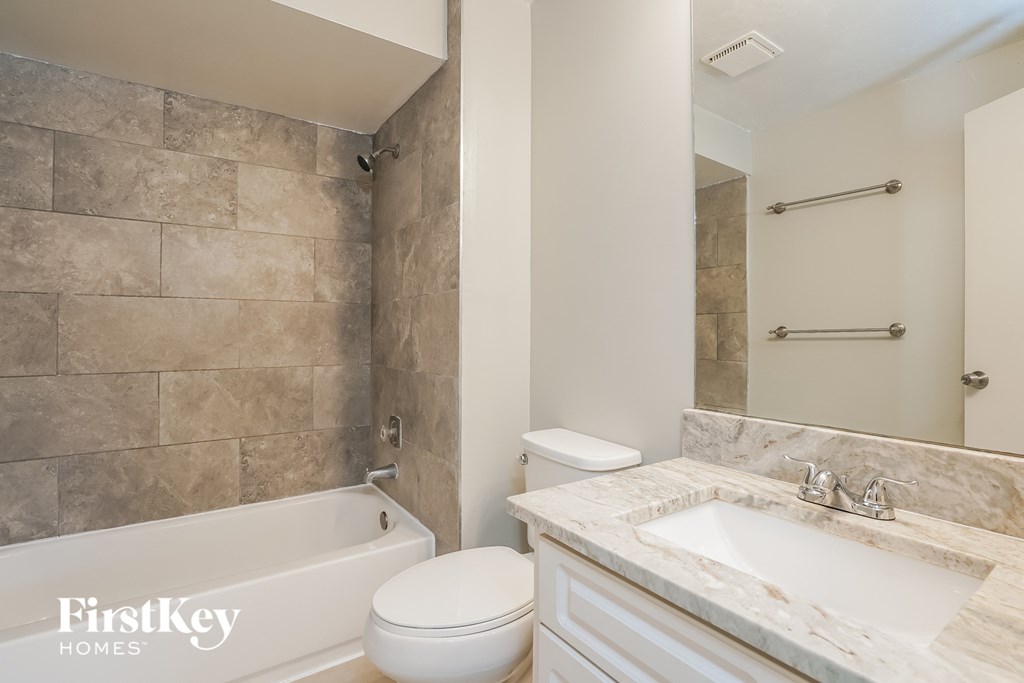 a bathroom with a sink toilet and bath tub and a mirror