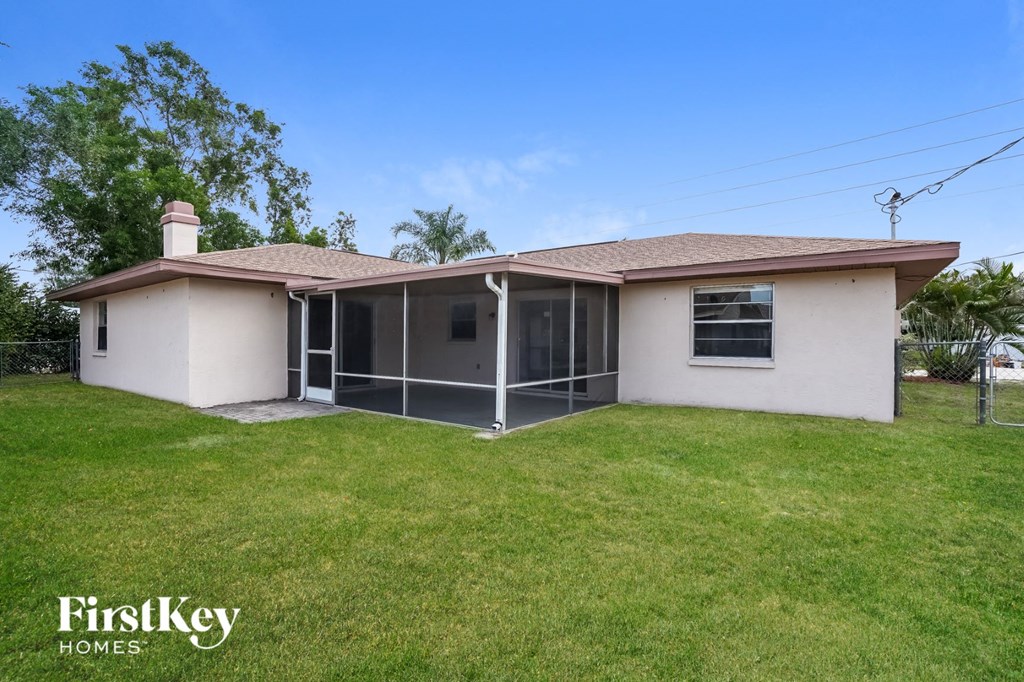 a small white house with a lawn and a screened in porch