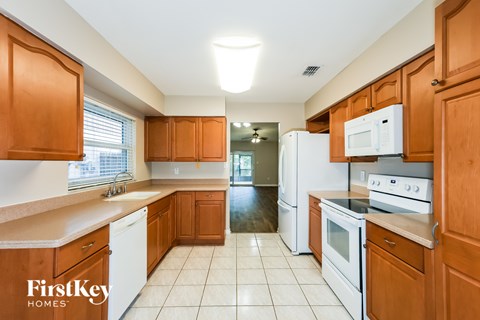 A kitchen with wooden cabinets and white appliances.