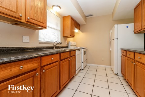 A kitchen with wooden cabinets and a white fridge.