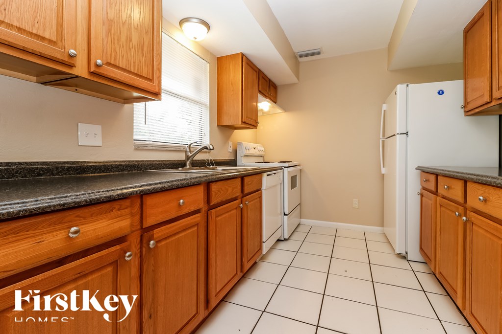 A kitchen with wooden cabinets and a white refrigerator.