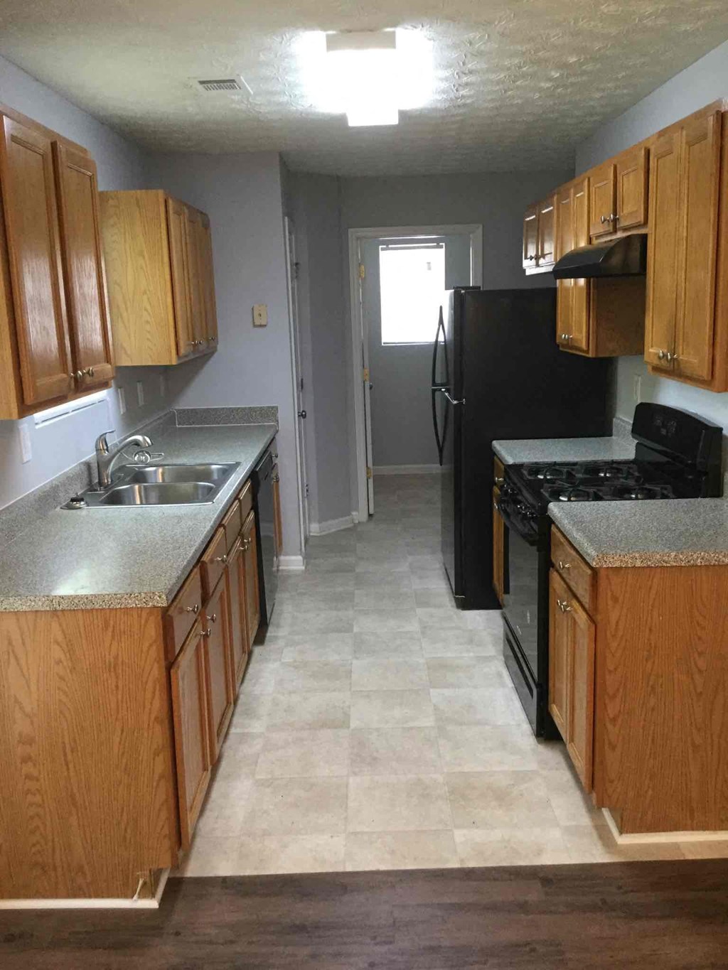 A kitchen with wooden cabinets and black appliances.