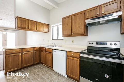 A kitchen with wooden cabinets and a black stove top oven.