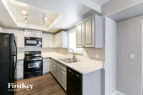 A kitchen with a black fridge and black oven.