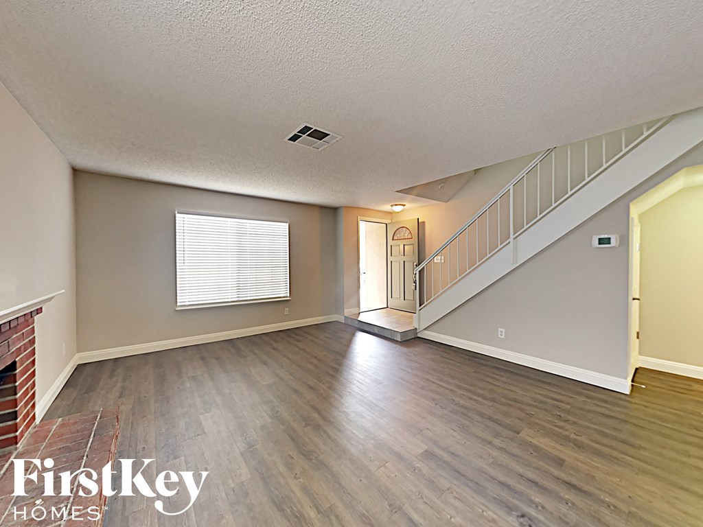 A spacious room with a staircase leading to the upper floor.