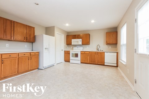 A kitchen with wooden cabinets and a white refrigerator.