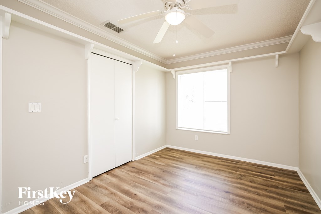 A room with a ceiling fan and a window.