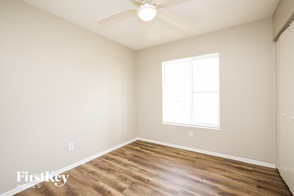 A room with a wooden floor and a ceiling fan.