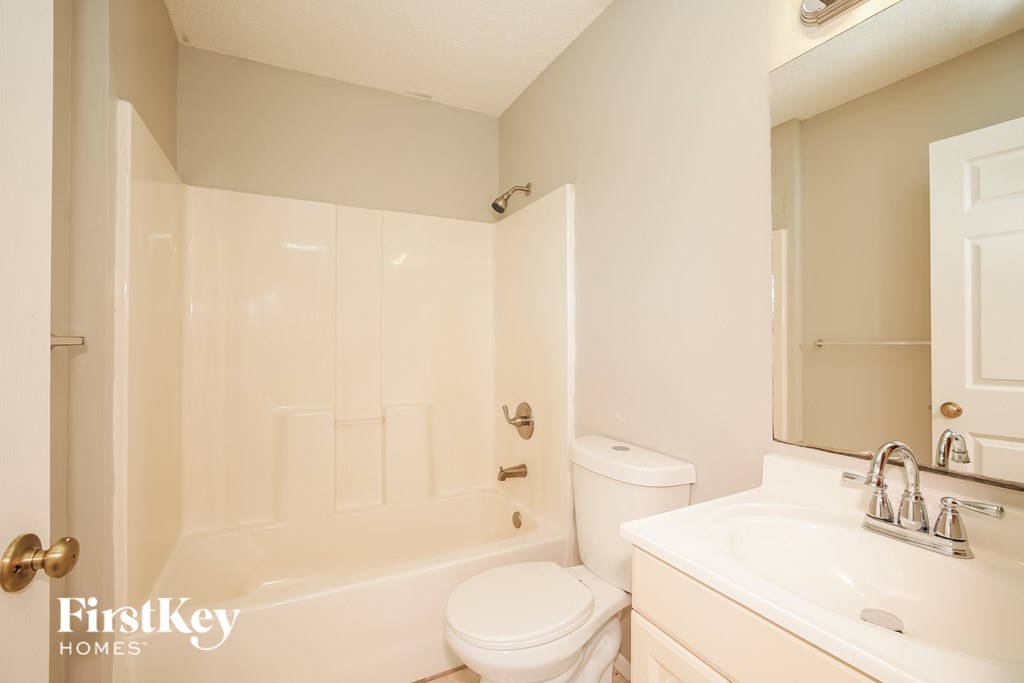 A white bathroom with a toilet, sink, and bathtub.