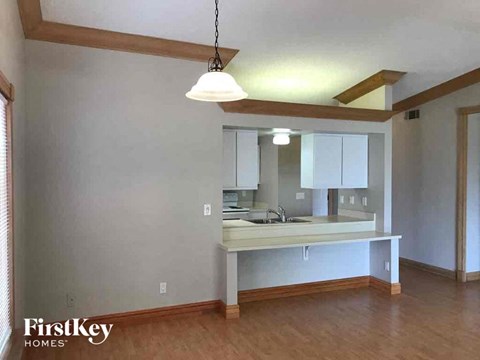 A kitchen with a white counter and a hanging light fixture.