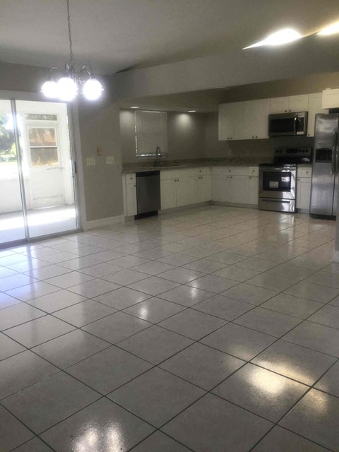 A kitchen with white cabinets and appliances.