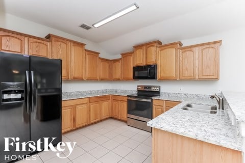 a kitchen with wooden cabinets and a sink and a refrigerator