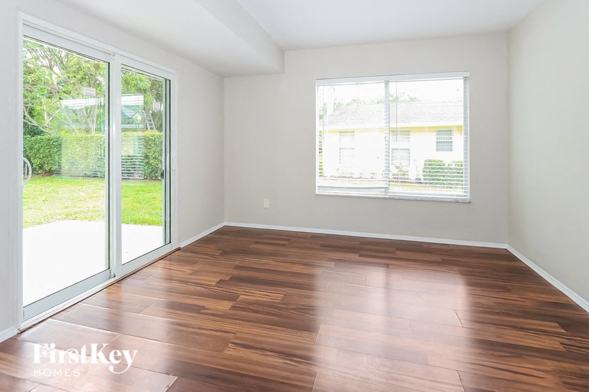 an empty living room with wood flooring and sliding glass doors
