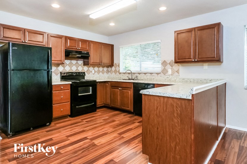 a kitchen with wooden cabinets and a black refrigerator