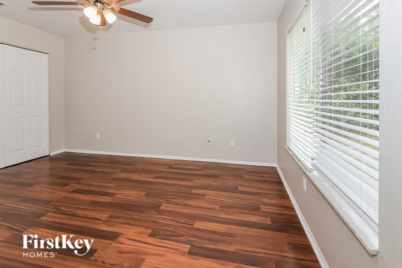 the living room with wood flooring and a large window