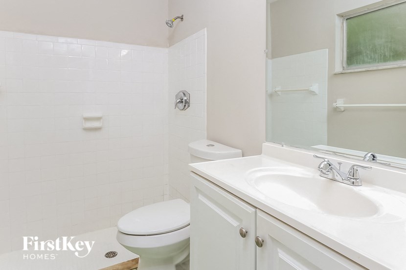 a white bathroom with a toilet sink and mirror