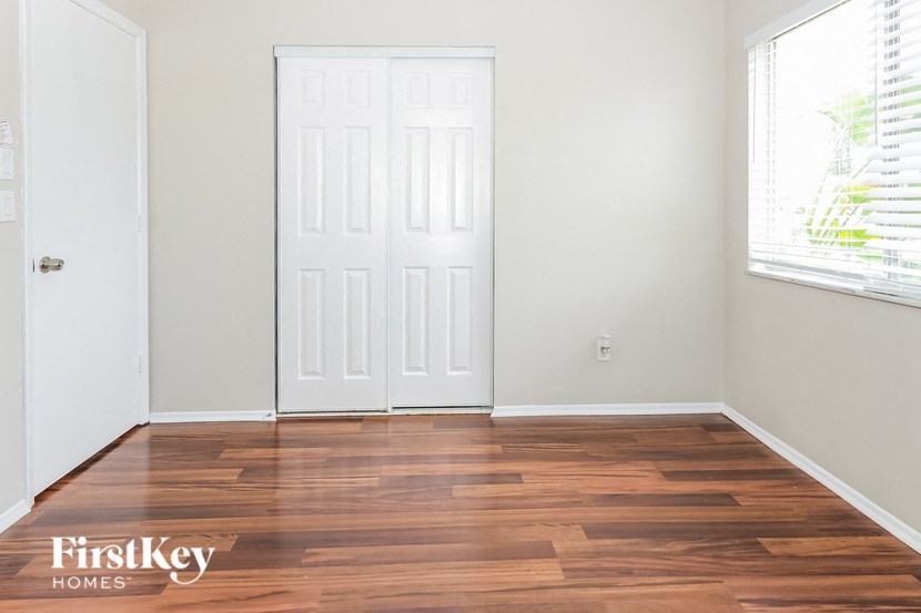 a clean and empty room with wooden floors and a white door