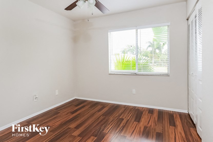 the living room with wood flooring and a large window