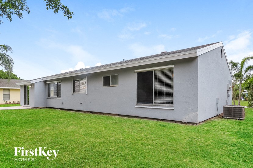 a white house with a green lawn and a blue sky