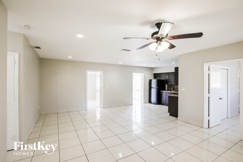 A spacious room with a ceiling fan and tiled flooring.