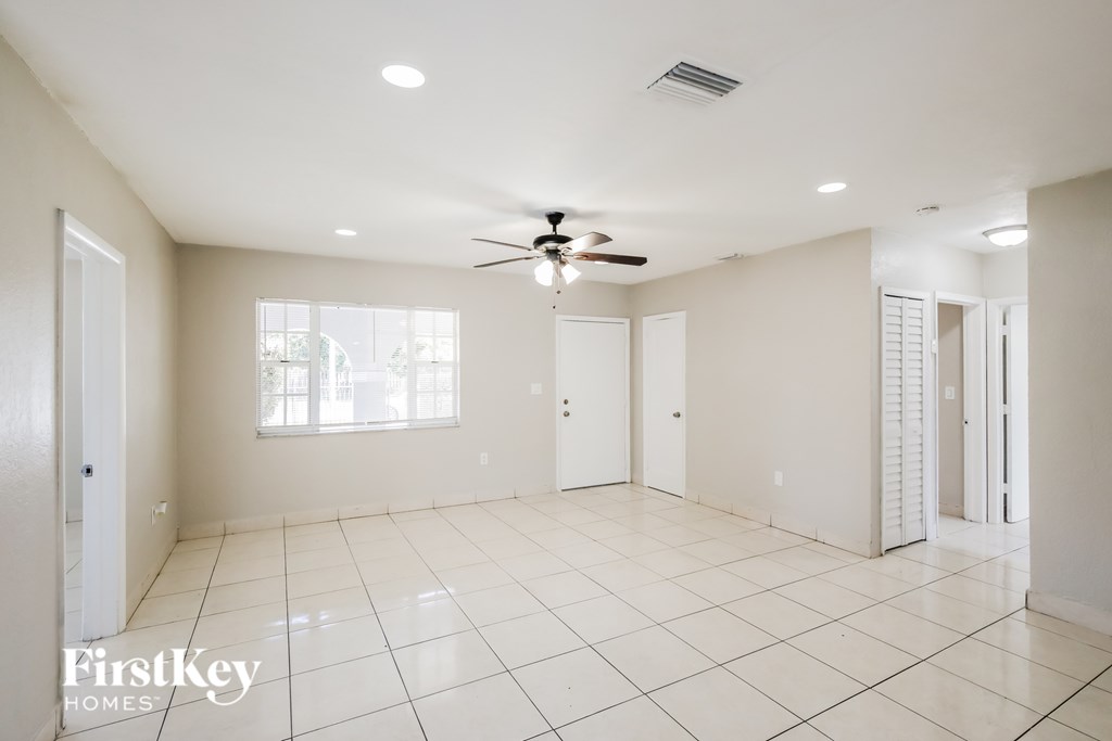 A spacious room with a ceiling fan and tiled flooring.
