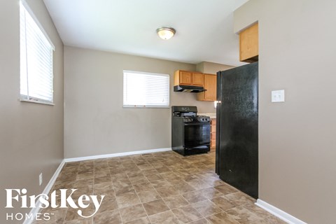 A kitchen area with a black refrigerator and a black oven.