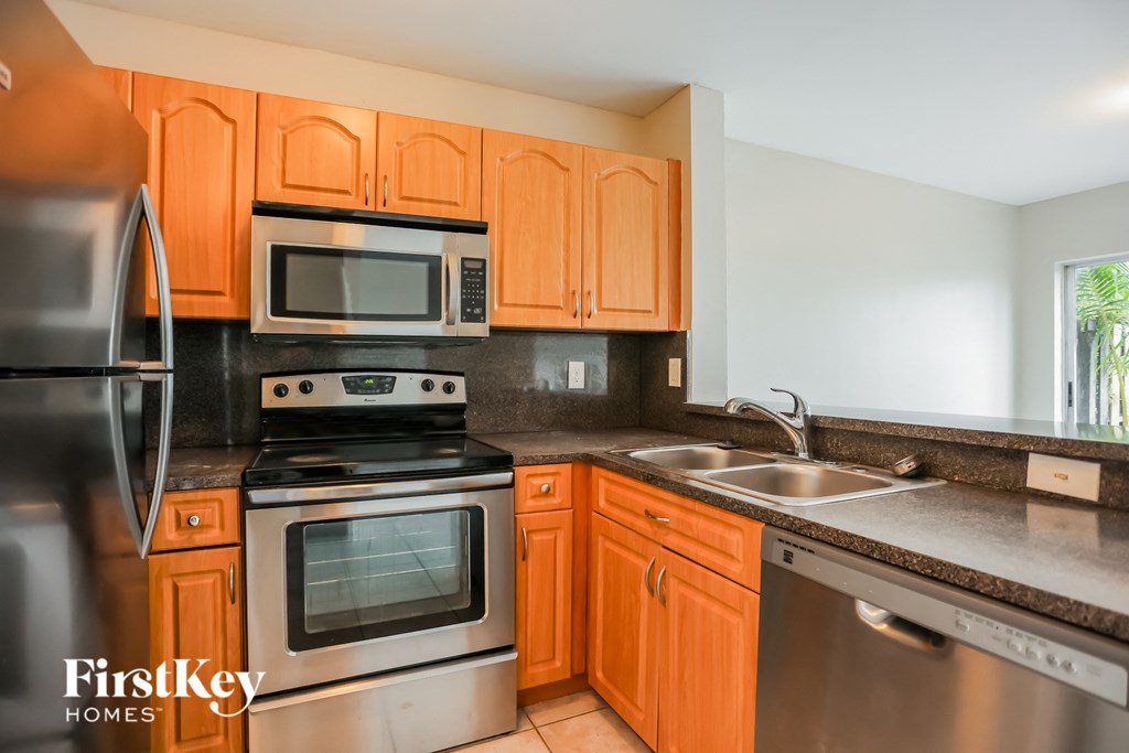 a kitchen with stainless steel appliances and wooden cabinets