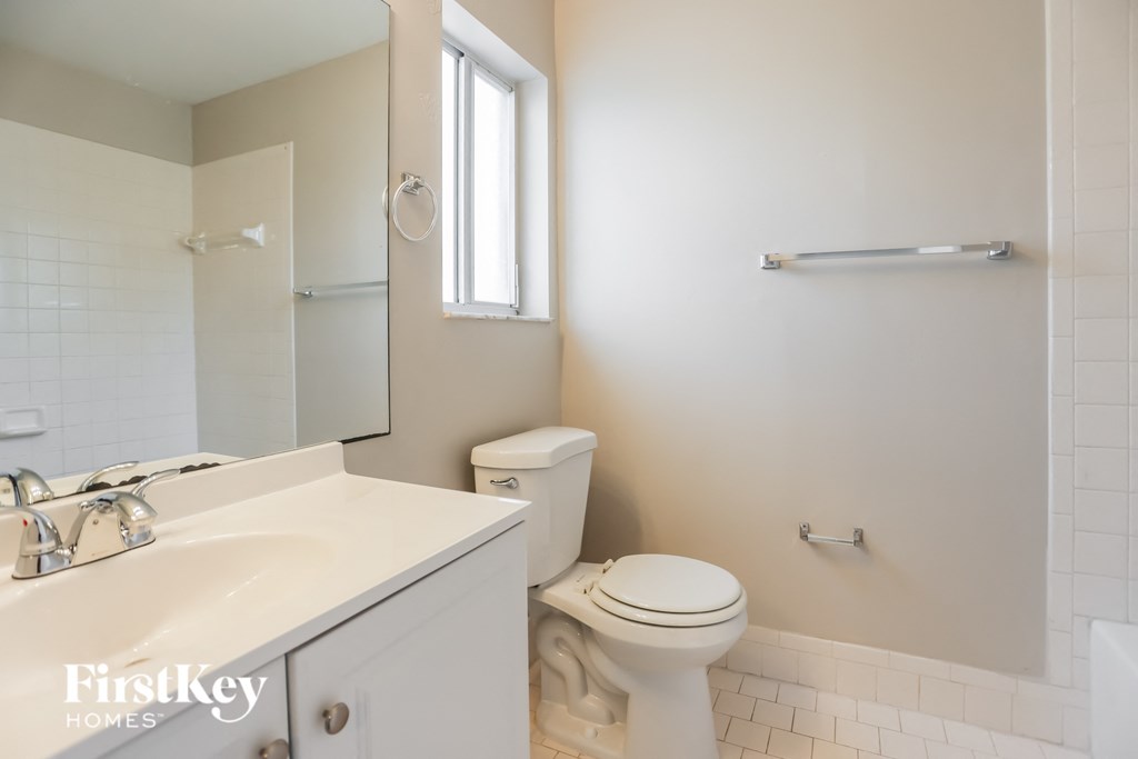 a white bathroom with a toilet and a sink