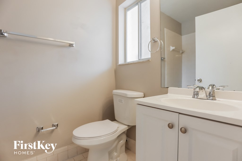 a bathroom with a toilet sink and a mirror