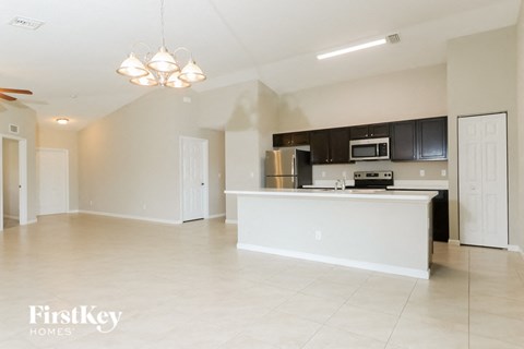 A kitchen with white cabinets and a white island.