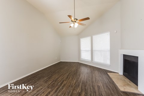 a living room with a ceiling fan and a fireplace